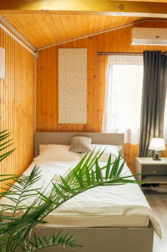 a bedroom with a bed and a palm tree in it at COMPLEX AGREMENT BELLAVI in Ocna-Mureşului