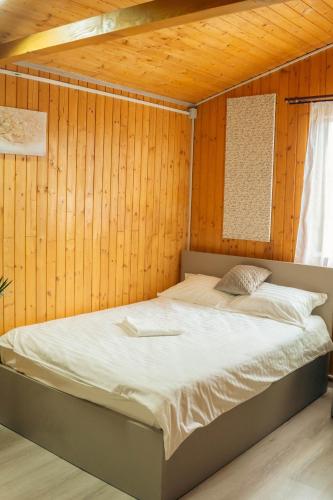 a bedroom with a bed in a wooden wall at COMPLEX AGREMENT BELLAVI in Ocna-Mureşului
