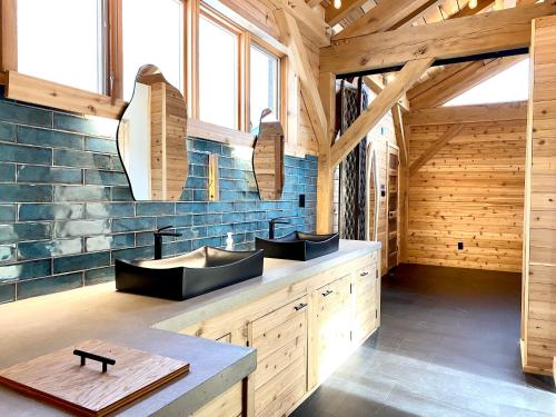 a bathroom with two sinks in a wooden building at The Arete Hostel and Suites in Summersville