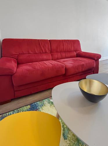un salon avec un canapé rouge et une table dans l'établissement Charme et calme proche centre, à Quimper