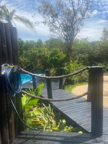 a wooden deck with a rope attached to a fence at Loft Chalé Recanto da Natureza in Imbituba