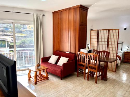 a living room with a red couch and a table at Apartamentos Edalmar in Frontera