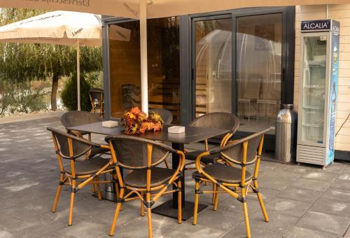 a table with chairs and an umbrella on a patio at COMPLEX AGREMENT BELLAVI in Ocna-Mureşului