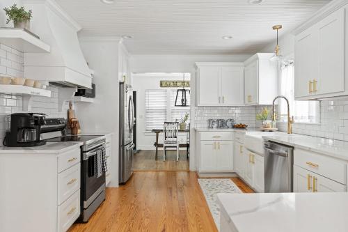 Una cocina blanca con gabinetes blancos y un fregadero. en Fraulein Haus walk to Main St sleeps 5, en Fredericksburg