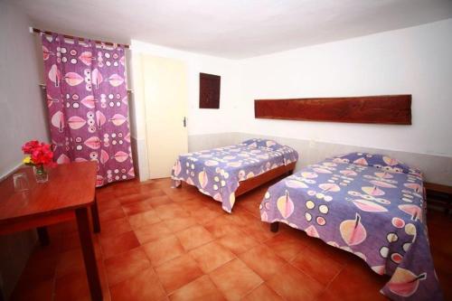 een kamer met 2 bedden, een tafel en een bureau bij Hôtel Katakalousse in Yembakana
