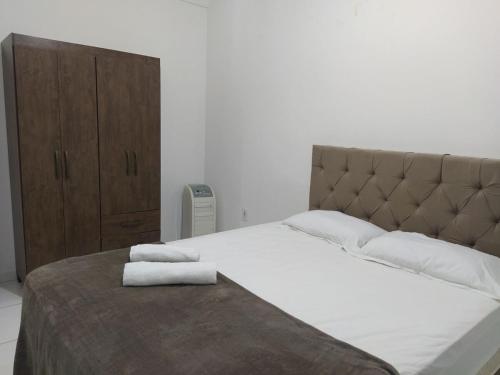 a bedroom with a large bed with two towels on it at Apartmento 304 Charmoso no Centro de Conquista in Vitória da Conquista