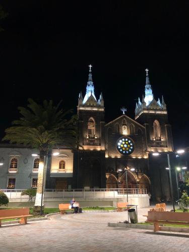 a large building with a clock tower at night at Andes Retreat 5 Bedroom 3 Bath in Baños