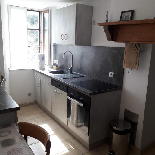 une cuisine avec un évier et une cuisinière four supérieur dans l'établissement Gite de l'Entressac, à Pradelles