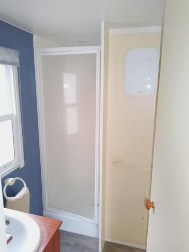 La salle de bains est pourvue d'une porte de douche et d'un lavabo. dans l'établissement ROEVMi, à Gère-Belesten