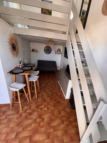 - un salon avec un escalier, une table et des chaises dans l'établissement Appartement proche Lydia à deux pas des déferlantes et de la grande plage, au Barcarès