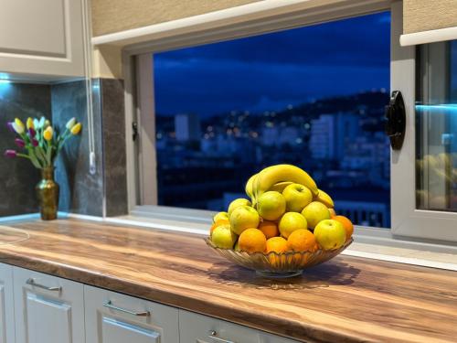 a bowl of fruit on a counter with a window at Queen Ekaterina II in Vlorë