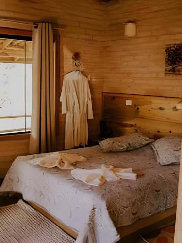 a bedroom with a bed and a dress on a dummy at Chalé Recanto da Mantiqueira in Gonçalves
