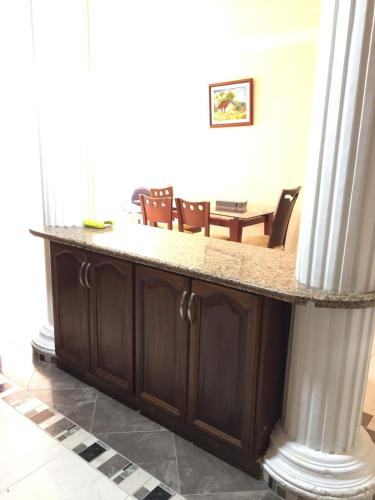 a counter with chairs and a table in a room at Casa Belén, Amplia, con Garaje y zona de trabajo in Roldanillo