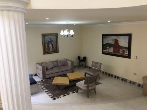 a living room with a couch and a table at Casa Belén, Amplia, con Garaje y zona de trabajo in Roldanillo