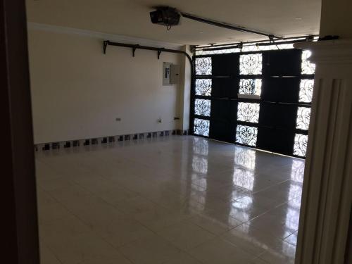 an empty room with a large window and a tile floor at Casa Belén, Amplia, con Garaje y zona de trabajo in Roldanillo