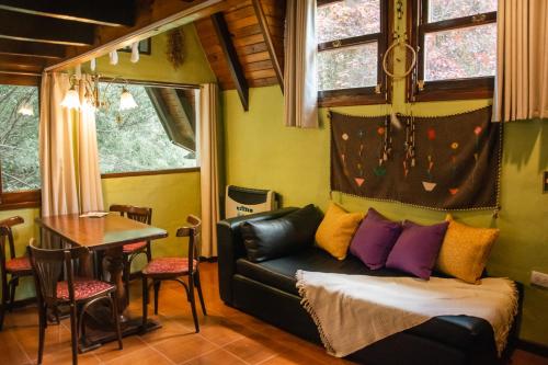ein Wohnzimmer mit Sofa und Tisch in der Unterkunft Apart del Bosque La Cumbrecita in La Cumbrecita