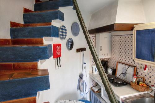 a kitchen with blue and white stairs and a sink at Charming House with Shared Pool in Porto de Mós. in Porto de Mós