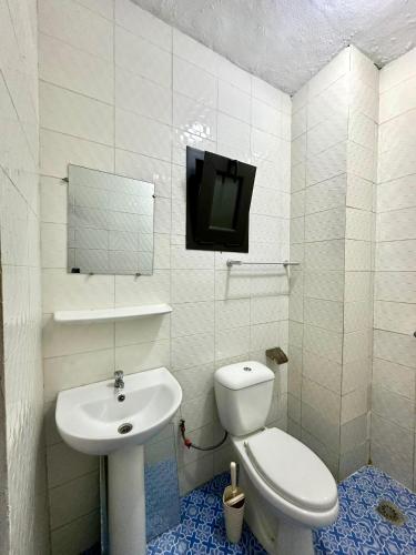 a bathroom with a sink and a toilet and a tv at Le spacieux-Salon XXL & 2 chambres in Cocody