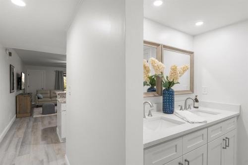 a white kitchen with a sink and a vase of flowers at Perfect Getaway Ponte Vedra Beach Lifestyle in Ponte Vedra