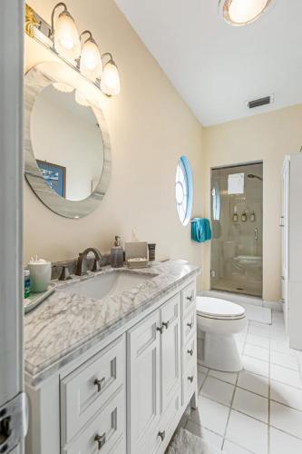 a bathroom with a sink and a toilet and a mirror at Windemere Inn by the Sea in Melbourne