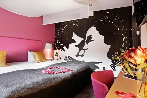 a bedroom with a bed and a pink wall at Hotel Svendborg in Svendborg