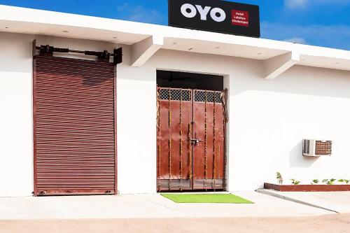 a white building with a gate and a door at SPOT ON Hotel Lakshya Ghatampur in Kānpur