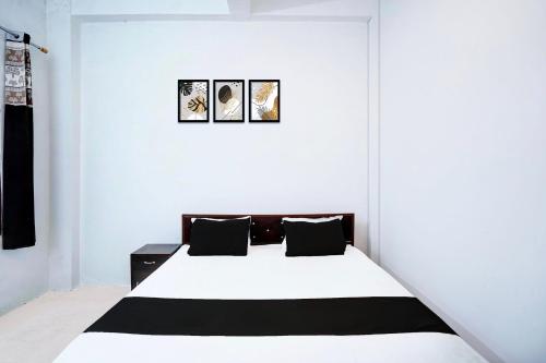 a white bedroom with a black and white bed at SPOT ON Hotel Lakshya Ghatampur in Kānpur