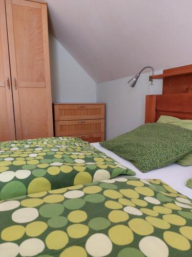 a bedroom with two beds with a green and yellow bedspread at Wellness Chata Rosnatka in Kvilda