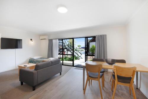 a living room with a couch and a table and chairs at Garden City Motel in Christchurch