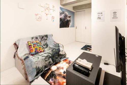 a living room with a couch and a table at TOKYO SKYTREE Cat house 押上駅徒歩6分 浅草 in Tokyo