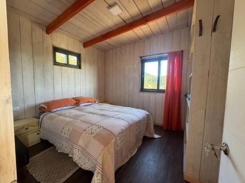 1 dormitorio con 1 cama en una habitación pequeña en Pullay Miramar cabaña, en Pullay