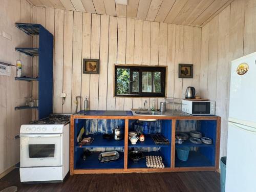una cocina con estufa y encimera en Pullay Miramar cabaña, en Pullay