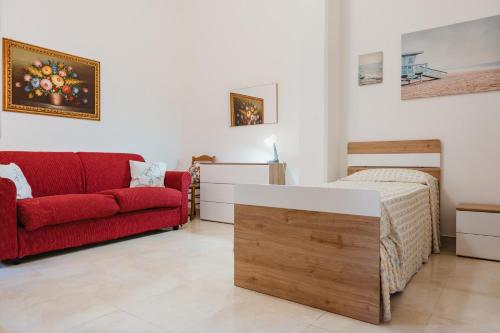 Un dormitorio con una cama y un sofá rojo. en Dimora Teresa, en San Pietro Vernotico
