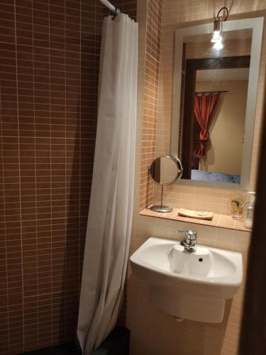 La salle de bains est pourvue d'un rideau de douche blanc et d'un lavabo. dans l'établissement Studio idéal court séjour, à Porté-Puymorens