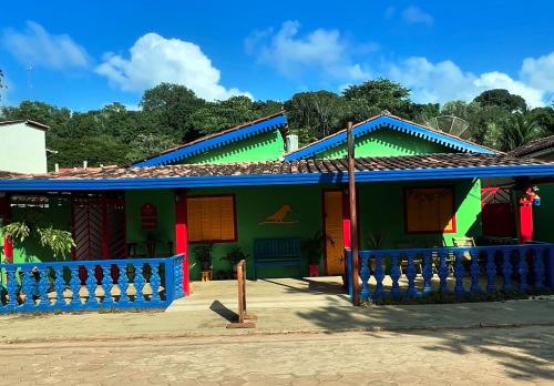 a colorful house with blue and green at Suítes e Chalé Colibri - Passarim Hospedagem in Cumuruxatiba