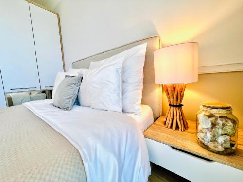 a bedroom with a bed and a lamp on a table at Rezydencja Niechorze MORSKIE WIDOKI 313 z Basenem i SPA - 5D Apartments in Niechorze