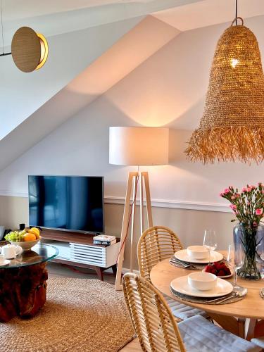 a living room with a table and a tv at Rezydencja Niechorze MORSKIE WIDOKI 313 z Basenem i SPA - 5D Apartments in Niechorze