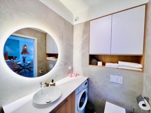 a bathroom with a sink and a washing machine at Rezydencja Niechorze MORSKIE WIDOKI 313 z Basenem i SPA - 5D Apartments in Niechorze