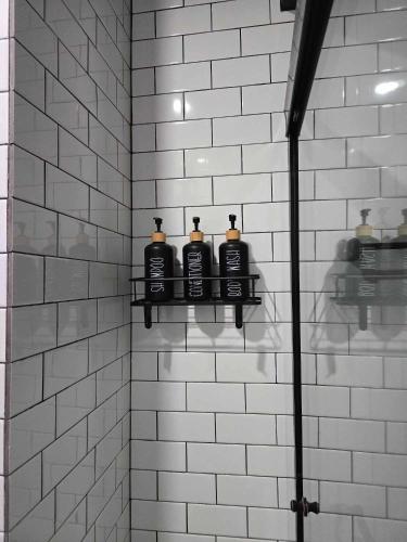 a bathroom with four bottles on a shelf in a shower at Whispering Bears Chalet in Gatlinburg