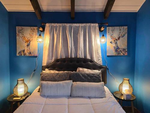 a bedroom with a bed with blue walls and two lamps at Whispering Bears Chalet in Gatlinburg