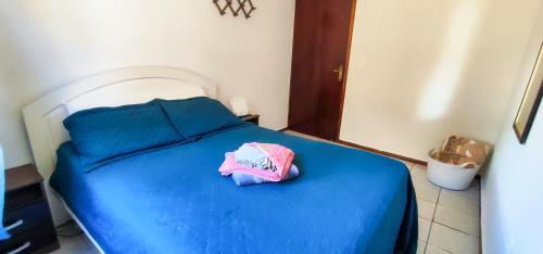 a blue bed with a pink hat on top of it at Quarto compartilhado Costa Norte in Florianópolis