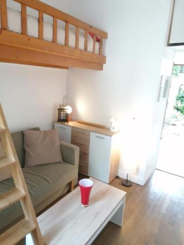 un salon avec un canapé et une tasse sur une table dans l'établissement Le Cosy Dijonnais - Disponible après le 1er Mai, à Dijon