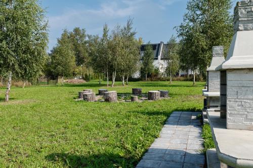 a park with a row of trees in the grass at Domki Ostoja - nad Bałtykiem - cisza i piękno natury in Zastań