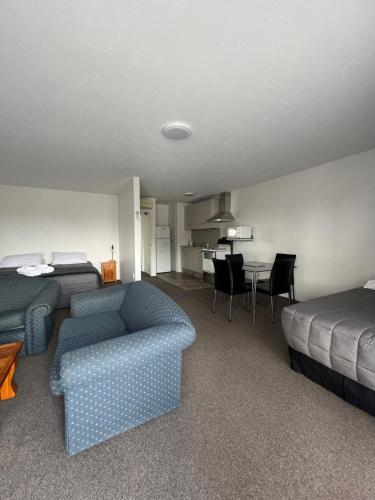 a room with a couch and a bed and a table at Garden City Motel in Christchurch