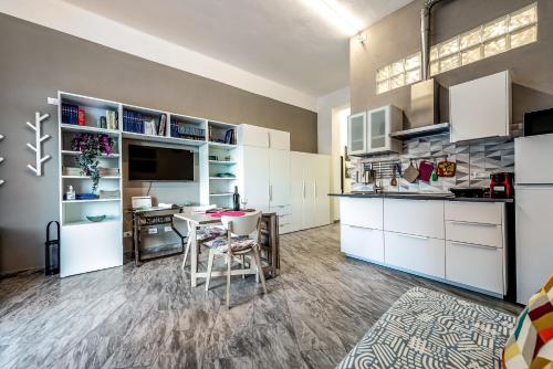 a kitchen with white cabinets and a table and chairs at Orlando's House - Pisa Downtown with View in Pisa