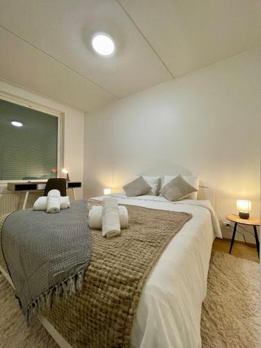 a bedroom with a large bed with white sheets and pillows at Penthouse Sauna Myyrmanni in Vantaa