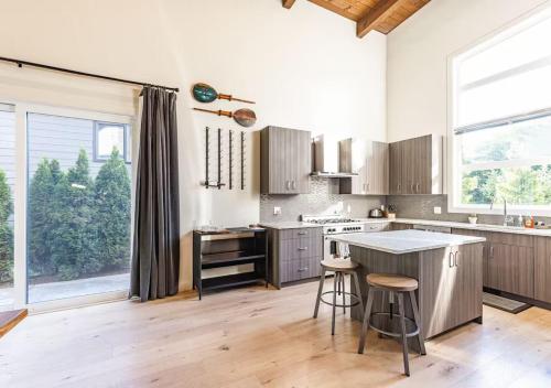 a kitchen with wooden floors and a large window at Large Modern Home in Squamish in Squamish