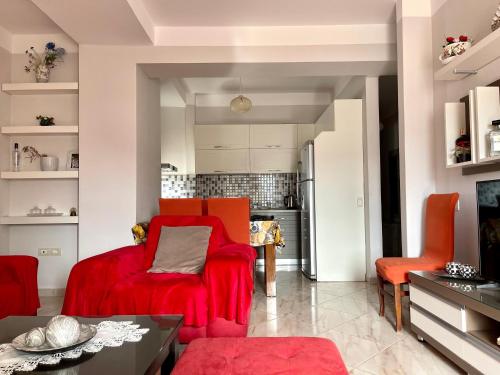 a living room with a red chair and a table at Queen Ekaterina II in Vlorë