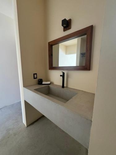 a bathroom with a sink and a mirror at Casa Amalia in Brisas de Zicatela