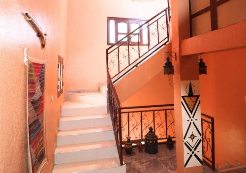 a staircase in a home with orange walls at Drâa Oasis House Palm Apartment in Ourhiz